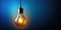 Vintage Incandescent Light Bulb Against a Deep Blue Background A Simple Glowing Element for Design and Concept Royalty Free Stock Photo