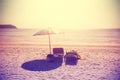 Vintage instagram stylized beach chairs and umbrella at sunset.
