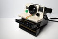 A vintage instant film camera loading a cassette on a white background. Royalty Free Stock Photo