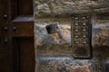 Vintage intercom at entrance to building. Old nameplate with buttons on bronze plate is on stone wall. Home security