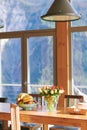 Vintage interior of dining room with design chair and table, vase with flowers and fruit bowl