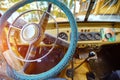 Vintage interior of an old car with a retro dashboard and steering wheel in a PVC cover Royalty Free Stock Photo