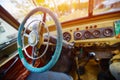 Vintage interior of an old car with a retro dashboard and steering wheel in a PVC cover Royalty Free Stock Photo