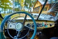 Vintage interior of an old car with a retro dashboard and steering wheel in a PVC cover Royalty Free Stock Photo