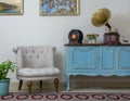 Retro off white armchair, vintage wooden light blue sideboard, old phonograph gramophone and vinyl records