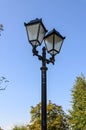 Vintage iron lighting pole with twin double lamp lantern on background of dark blue sky Royalty Free Stock Photo