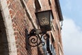 HOEGAARDEN, BELGIUM - SEPTEMBER 04, 2014: Vintage iron street lamp on the wall of an old red brick building. Royalty Free Stock Photo