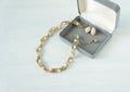 Vintage jewelry background. Beautiful gold and pearl necklace and earrings in a gift box on white wood. Flat lay