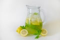 Vintage jug with refreshing non alcoholic mojito drink with lemon slices, mint leaves and ice. Studio shot of iced lemonade Royalty Free Stock Photo