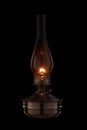 Vintage kerosene lamp burning on black background. Glass old oil lamp