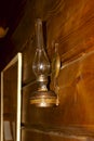 Vintage kerosene lamp with glass and wick hanging on a wooden wall Royalty Free Stock Photo