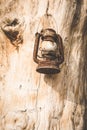 Vintage kerosene lamp hanging on hook on grunge wooden wall