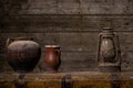 Vintage kerosene lamp and an two empty clay vases on wooden table over grunge wooden background