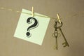 Vintage key hanging on a rope on a gold background, next sticker with question mark Royalty Free Stock Photo