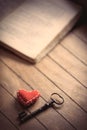 Vintage key with heart shape and old books Royalty Free Stock Photo