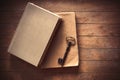 Vintage key and old books on wooden table. Royalty Free Stock Photo