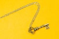 Vintage key with silver chain isolated on yellow background