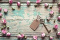 Vintage key with a tag and a little pink roses on an old wooden Royalty Free Stock Photo