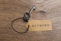 Vintage key and tag wIth word KEYWORD on wooden table, top view Royalty Free Stock Photo
