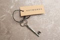 Vintage key and tag wIth word KEYWORDS on grey table, top view Royalty Free Stock Photo