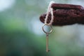 Vintage key with wooden home keyring hanging on old wood plank with blur green garden background, copy space Royalty Free Stock Photo