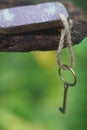 Vintage key with wooden home keyring hanging on old wood plank with blur green garden background, copy space Royalty Free Stock Photo