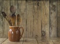 Vintage kitchen utensils in the jug on the rustic wooden background Royalty Free Stock Photo