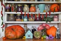 Vintage kitchen with wooden counters full of old utensils, bottles and jars with beans, herbs, spice, hanging hot pepper and