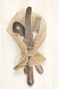 Vintage knife, fork and spoon on white wooden background. Royalty Free Stock Photo