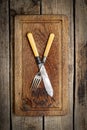 Vintage knife and fork on a wooden background, top view