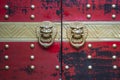 Vintage knocker door handles Asian style on the red painted doors. Lion door handle rings