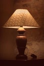 A vintage lamp beside a bed