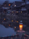 Vintage lamp with candle inside over blurry hostel background with pentagon bokeh Royalty Free Stock Photo