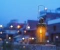 Vintage lamp with candle inside over blurry hostel background with pentagon bokeh Royalty Free Stock Photo