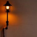 Vintage lamp fixture on wall, dark warm glow, empty wall