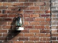 A vintage lamp hangs on old brick wall