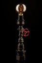 Vintage lamp made from steel water pipe fittings with filament bulb and valve switch, on black background Royalty Free Stock Photo