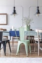 Vintage lamps and green chair at the table in a simple dining room interior. Real photo Royalty Free Stock Photo