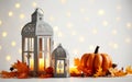 Vintage lantern with burning candle over white background, decorated in autumnal style, pumpkins, maple leaves. Royalty Free Stock Photo