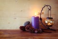 Vintage Lantern with burning Candle and pine cones on wooden table. filtered image. Royalty Free Stock Photo