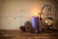 Vintage Lantern with burning Candle and pine cones on wooden table. filtered image. Royalty Free Stock Photo