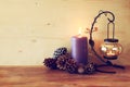 Vintage Lantern with burning Candle and pine cones on wooden table. filtered image Royalty Free Stock Photo