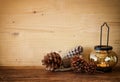 Vintage Lantern with burning Candle and pine cones on wooden table. filtered image Royalty Free Stock Photo