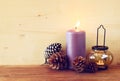 Vintage Lantern with burning Candle and pine cones on wooden table. filtered image. Royalty Free Stock Photo