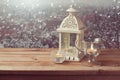 Vintage lantern with candles over winter town background with copy space