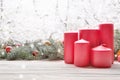 Vintage lantern red candles with Christmas fir tree garland on wooden board on window sill over nature snowing tree park Royalty Free Stock Photo