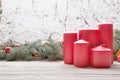 Vintage lantern red candles with Christmas fir tree garland on wooden board on window sill over nature snowing tree park backgroun Royalty Free Stock Photo