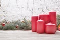 Vintage lantern red candles with Christmas fir tree garland on wooden board on window sill over nature snowing tree park Royalty Free Stock Photo