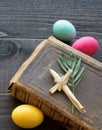 Vintage Leather Bible with grass cross, palm leaves, Colorful Easter Eggs on Dark Rustic Wood Board