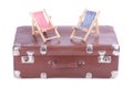 Vintage leather suitcase with two toy beach chairs Royalty Free Stock Photo